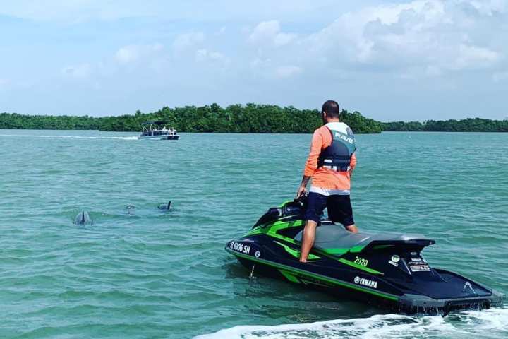 a man riding on the back of a boat in the water